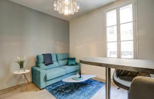 un salon avec un canapé bleu et une table dans l'établissement Le Modernisme - Tours, à Tours