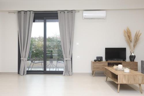 a living room with a tv and a table at JΕΝΑ House in (( Agía Eleoúsa ))