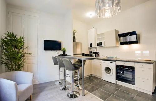 une cuisine avec un comptoir, un lave-linge et un sèche-linge dans l'établissement Le Modernisme - Tours, à Tours