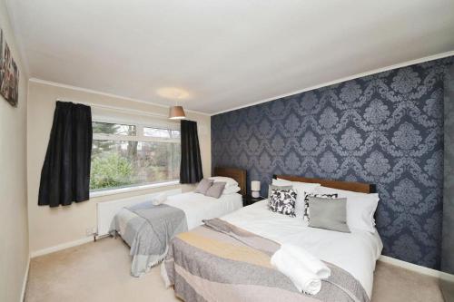 a bedroom with two beds and a window at Beautiful home close to town Free Netflix, Wifi in Solihull