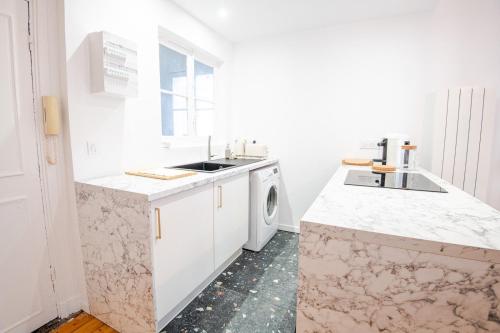 una cucina bianca con lavandino e lavatrice di Le Petit Amandier - Tours a Tours