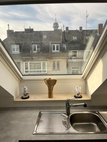 a kitchen sink with a view of a window at Fürstenwall Suite in Düsseldorf