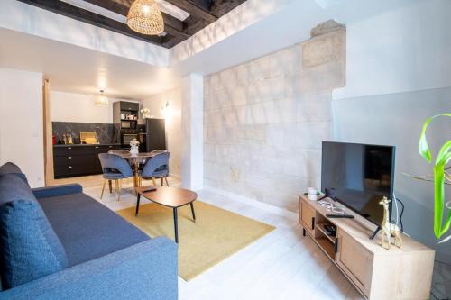 a living room with a blue couch and a tv at At the heart of Vieux Tours festivities in Tours