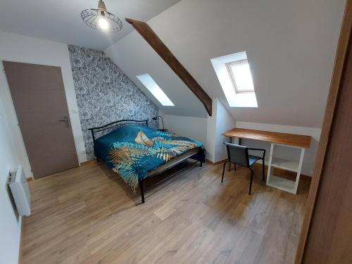 - une chambre mansardée avec un lit et un bureau dans l'établissement Au coin de la brasserie, à Cappellebrouck