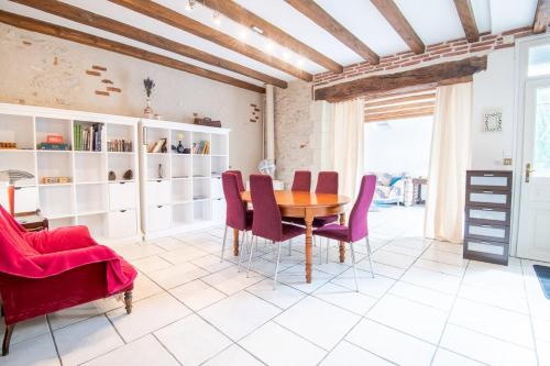 une salle à manger avec une table en bois et des chaises rouges dans l'établissement Le Stalingrad - Saint-Pierre-des-Corps, à Saint-Pierre-des-Corps