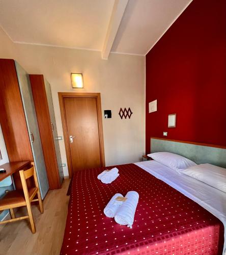 a bedroom with a bed with two towels on it at Hotel Villa Tina in Cesenatico