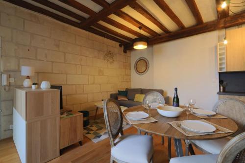 a dining room with a table and chairs and a couch at Lovely T2 in the heart of Tours in Tours