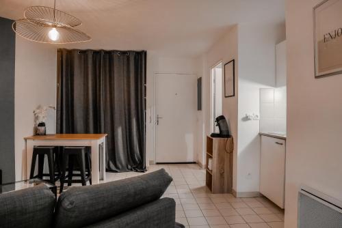 een woonkamer met een bank en een tafel bij St-OrensBnB - Cosi - WIFI - Parking - Terrasse in Saint-Orens-de-Gameville