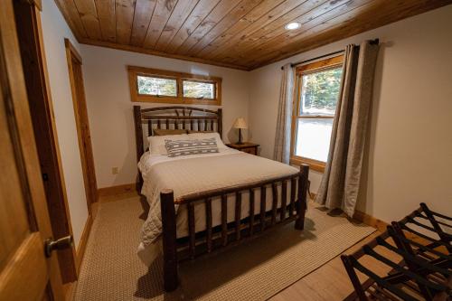 1 dormitorio con cama de madera y ventana en Daggett Lodge, en Warrensburg