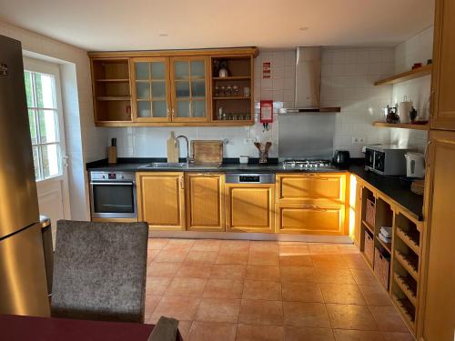 a large kitchen with wooden cabinets and appliances at Casa do Olival in Tarouca
