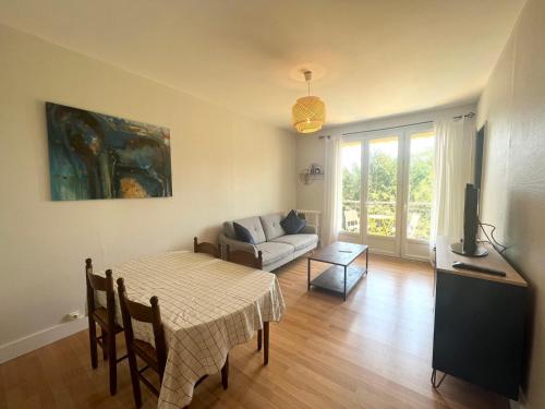 una sala de estar con una mesa y un sofá en Le Soleil Levant - Beau T3 moderne et lumineux, en Poitiers