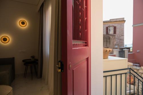 a red door in a room with a balcony at Silo Luxury Rooms in Nafplio