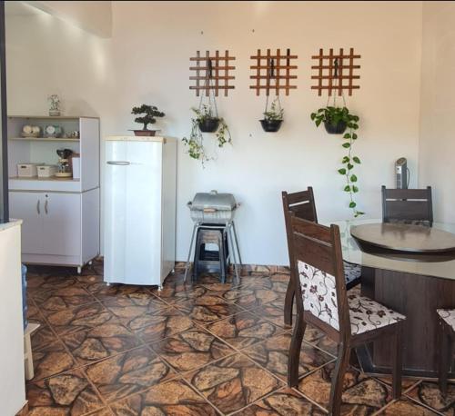 a kitchen with a refrigerator and a table and chairs at Rose House in Arraial do Cabo