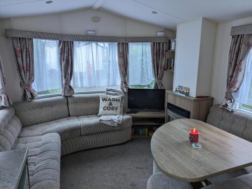 a living room with a couch and a table at Homely 2 bed caravan sleeps 4 5 in Portland Dorset in Portland