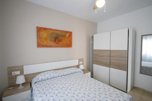 ミアミ・プラトーヤにあるLas Marinas Bのベッドルーム1室(ベッド1台付)が備わります。壁には絵画が飾られています。