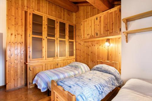 sypialnia z 2 łóżkami i drewnianymi ścianami w obiekcie Casa Vacanza Menfrey w mieście Verrayes