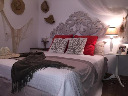 a bedroom with a large bed with red pillows at Smeralda Residenza Di Charme in Marina di Portisco