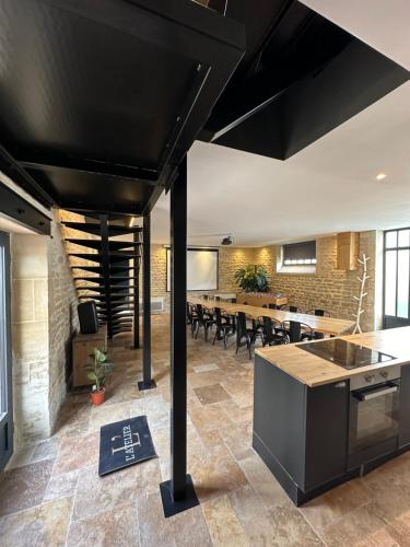 an open kitchen and dining room with a long table at L'ATELIER DU VIEUX BOIS Spa in Bayeux