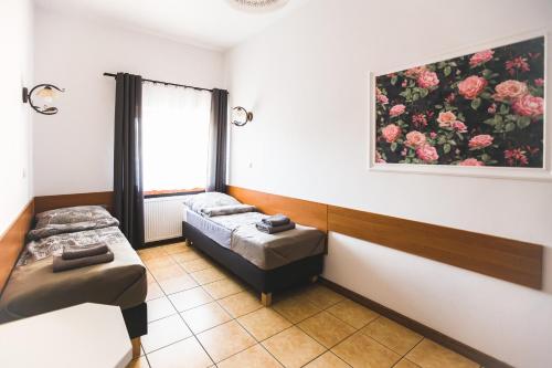 a room with two beds and a painting on the wall at Pokoje gościnne LECH in Gubin