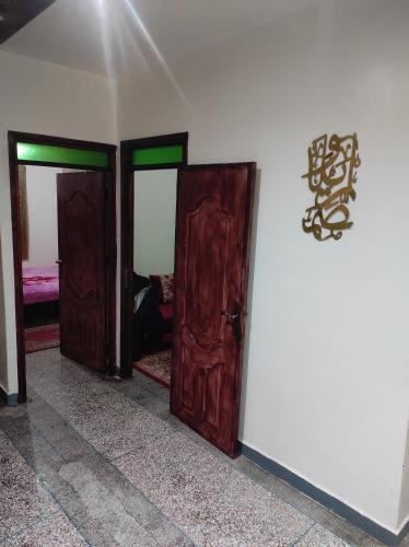 3 portes en bois dans une pièce avec un mur dans l'établissement Appartement situé à 5 minutes à pied de l'Aeroport de Marrakech, à Marrakech