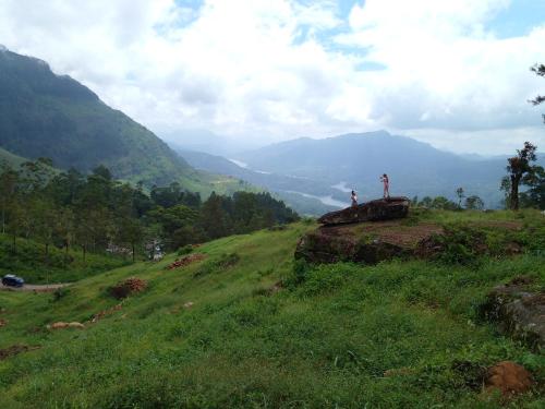 uma pessoa no topo de uma colina relvada em New Toropi Homestay em Gadaladeniya