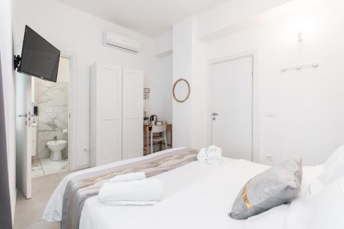 una camera bianca con letto e TV di VittorioVeneto126 a La Spezia