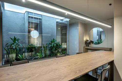 a conference room with a long wooden table and plants at Zakro Luxury Living Chania in Chania Town