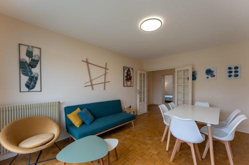 un salon avec un canapé bleu et une table dans l'établissement Appartement BONDY chaleureux - 2 chambres, à Bondy