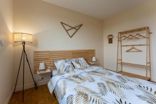 une chambre avec un lit avec une couette bleue et blanche dans l'établissement Appartement BONDY chaleureux - 2 chambres, à Bondy