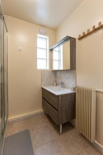 une salle de bain avec un lavabo, un miroir et une douche dans l'établissement Appartement BONDY chaleureux - 2 chambres, à Bondy