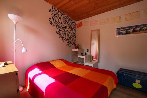 a bedroom with a colorful bed in a room at Maison familiale en bois proche du lac de Cazaux in La Teste-de-Buch