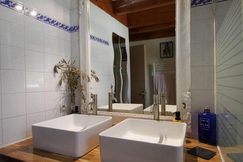 a bathroom with two white sinks and a mirror at Maison familiale en bois proche du lac de Cazaux in La Teste-de-Buch