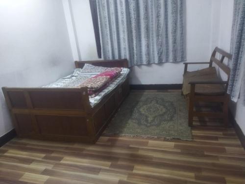 a small bedroom with a bed and a chair at LOTA home in Kathmandu