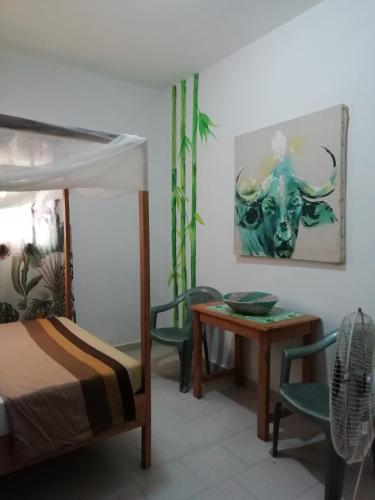 a bedroom with a bed and a table and chairs at Maison Manour, chambre 'Jungle' in Mbour