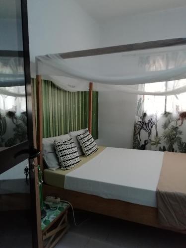 a bedroom with a bed with a canopy at Maison Manour, chambre 'Jungle' in Mbour
