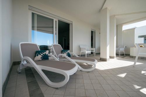 un gruppo di sedie seduti su un balcone di Milena Suite Apartments ad Alghero
