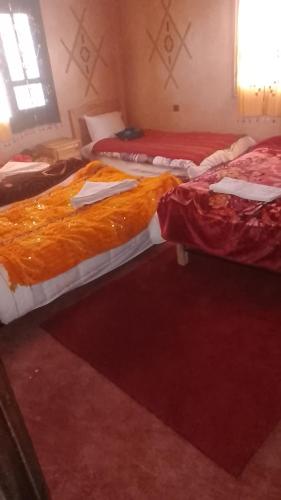 a group of three beds in a room at Kasbah Tialouite in Kalaat MGouna