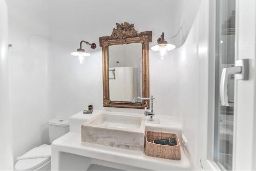 a white bathroom with a sink and a mirror at MichaelAngelo Villa in Mýkonos City