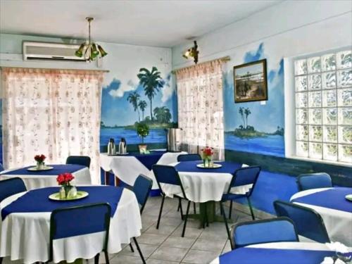 a dining room with blue tables and blue chairs at Brakendene Lodge in Gaborone