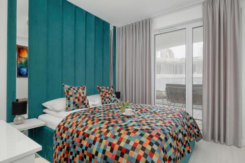 a bedroom with a bed with a colorful blanket at Rogowo Pearl Turquoise Apartments Near The Sea with FREE PARKING by Renters in Rogowo