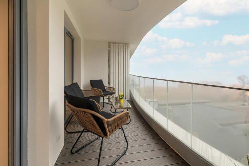 a balcony with chairs and a view of an airport at Rogowo Pearl Turquoise Apartments Near The Sea with FREE PARKING by Renters in Rogowo