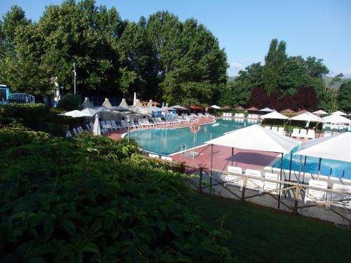 a large pool with white umbrellas and a resort at Camping Village la Chiocciola in Capannole