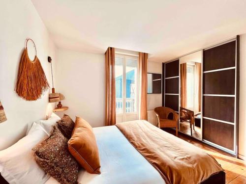 une chambre avec un grand lit et une grande fenêtre dans l'établissement La Terrasse Saint Sauveur, à Toulouse