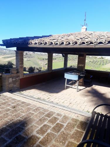 a patio with a roof with a table and a bench at Casalustro in Citta' Sant'Angelo