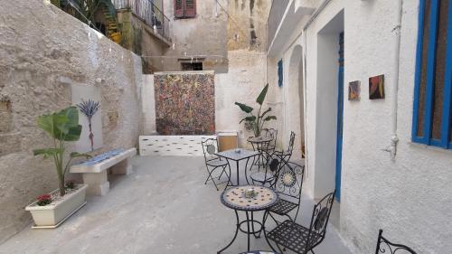 een terras met tafels en stoelen in een steeg bij Nastanza D'arte in Mazara del Vallo
