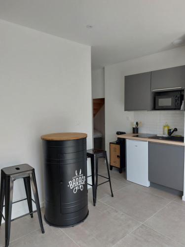 uma cozinha com um caixote do lixo no meio de uma sala em Studio tout confort à 500 m de la mer em Bretignolles-sur-Mer