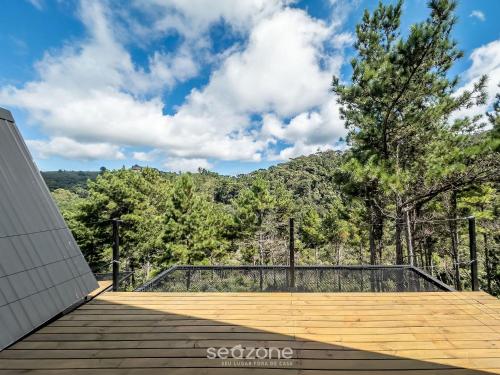 a wooden boardwalk with a view of the mountains at Chales Naturale - Campos do Jordão - CNA in Campos do Jordão