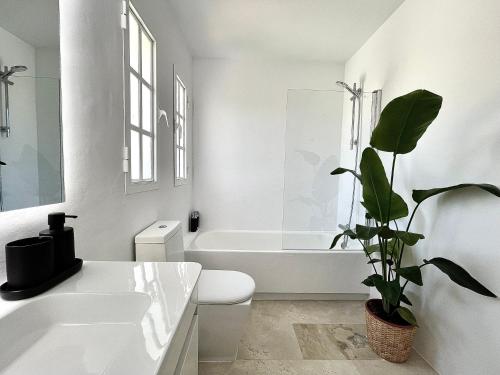 a bathroom with a white tub and a toilet and a plant at 4 bedroom Villa in Top location - Heating Pool in Marbella