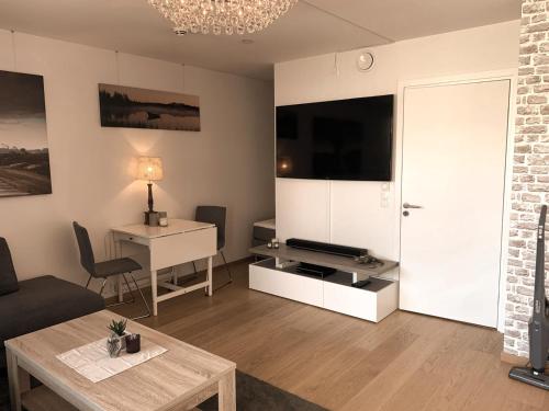 sala de estar con sofá, mesa y TV en MyCondo no - Rambergveien 14a, en Tønsberg