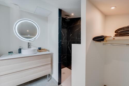 une salle de bain avec un lavabo et un miroir dans l'établissement Style et caractère, climatisation, à Toulouse